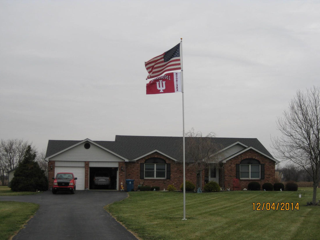 A telescoping flagpole flying a sports flag and an american flag