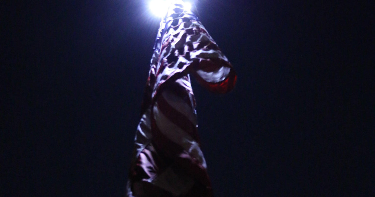 Solar flagpole light for dusk-to-dawn illumination