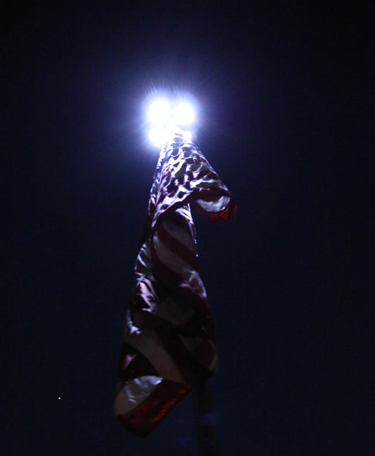 solar lights on top of a flagpole at night