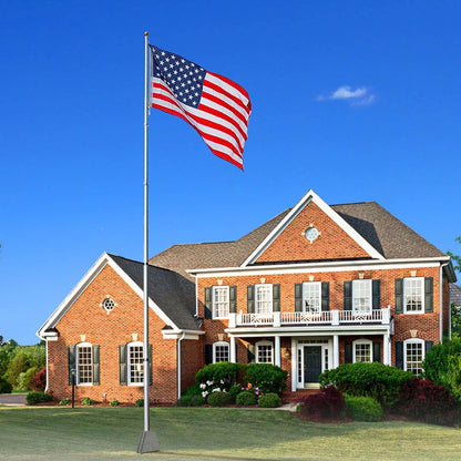 Heavy duty silver American flag display pole from Atlantic Flagpole, featuring a waving American flag outside a brick house.