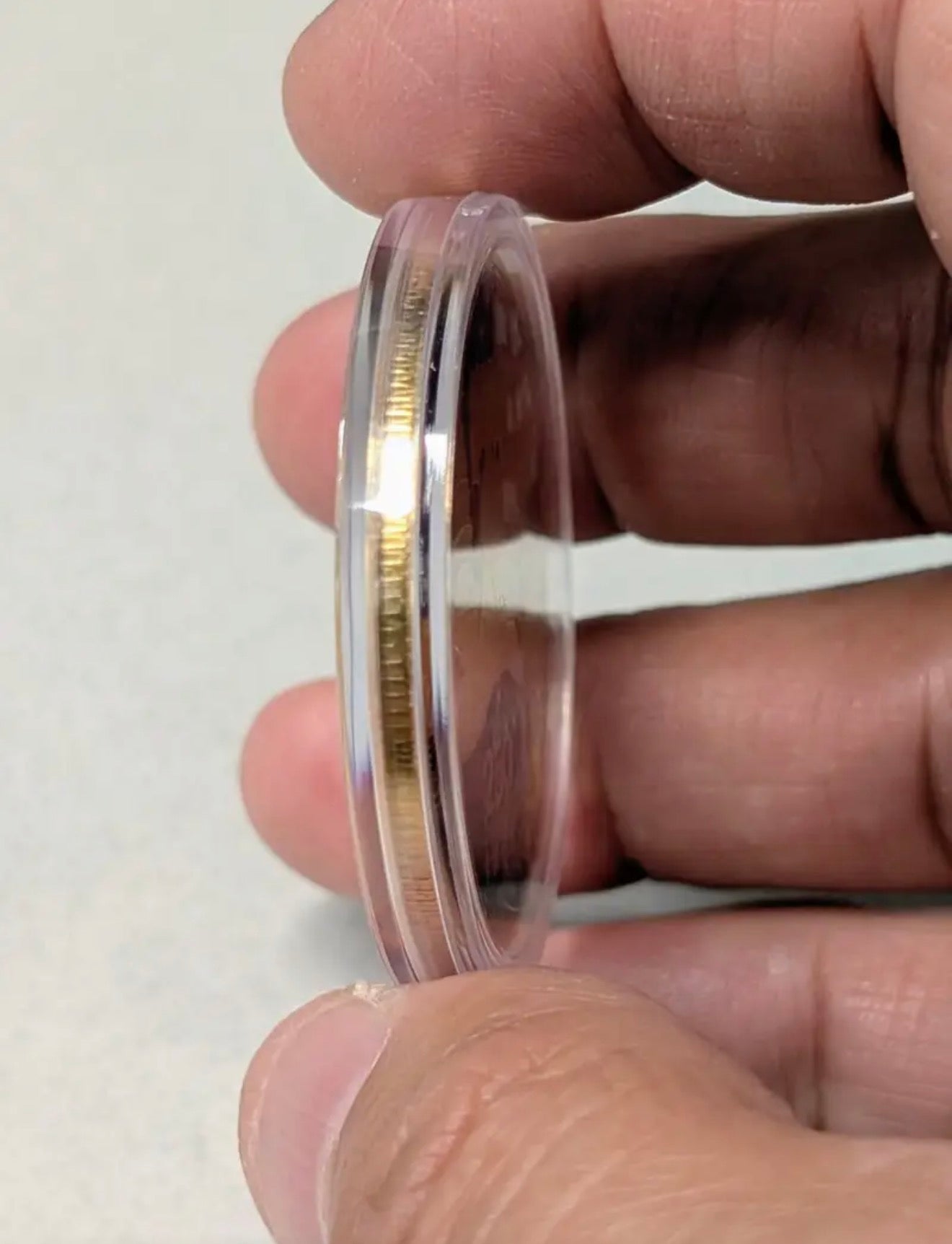 America 250 Challenge Coin side thickness shown held in fingers