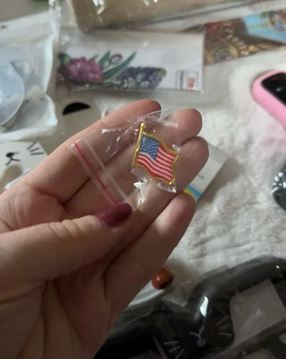 American Flag Lapel Pin held in hand for scale