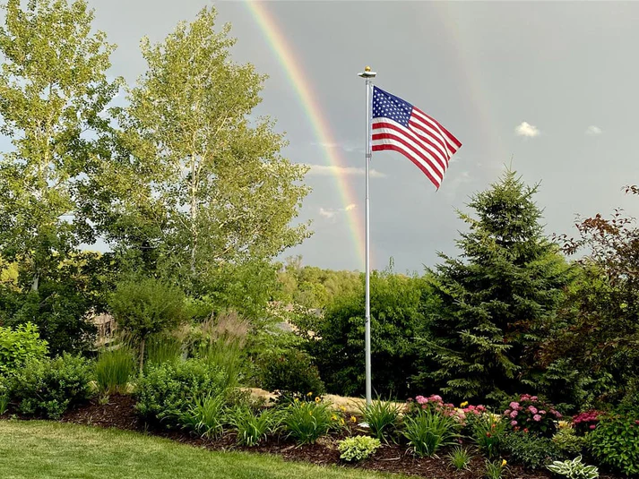 A Phoenix telescoping flagpole flying the American flag at a customer's home