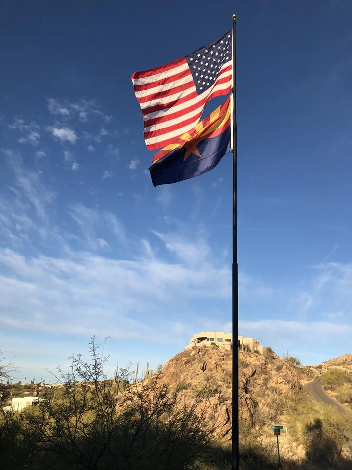 A Phoenix telescoping flagpole flying the American flag at a customer's home
