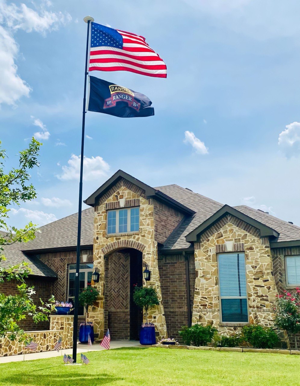 A Phoenix telescoping flagpole flying the American flag at a customer's home