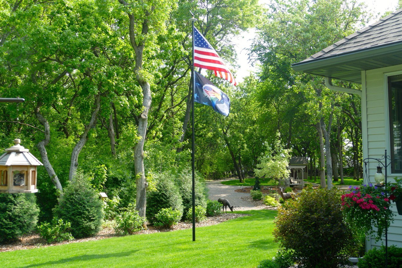 A Phoenix telescoping flagpole flying the American flag at a customer's home