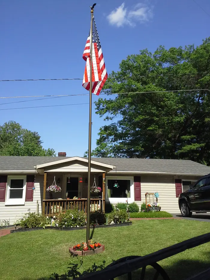 A Phoenix telescoping flagpole flying the American flag at a customer's home