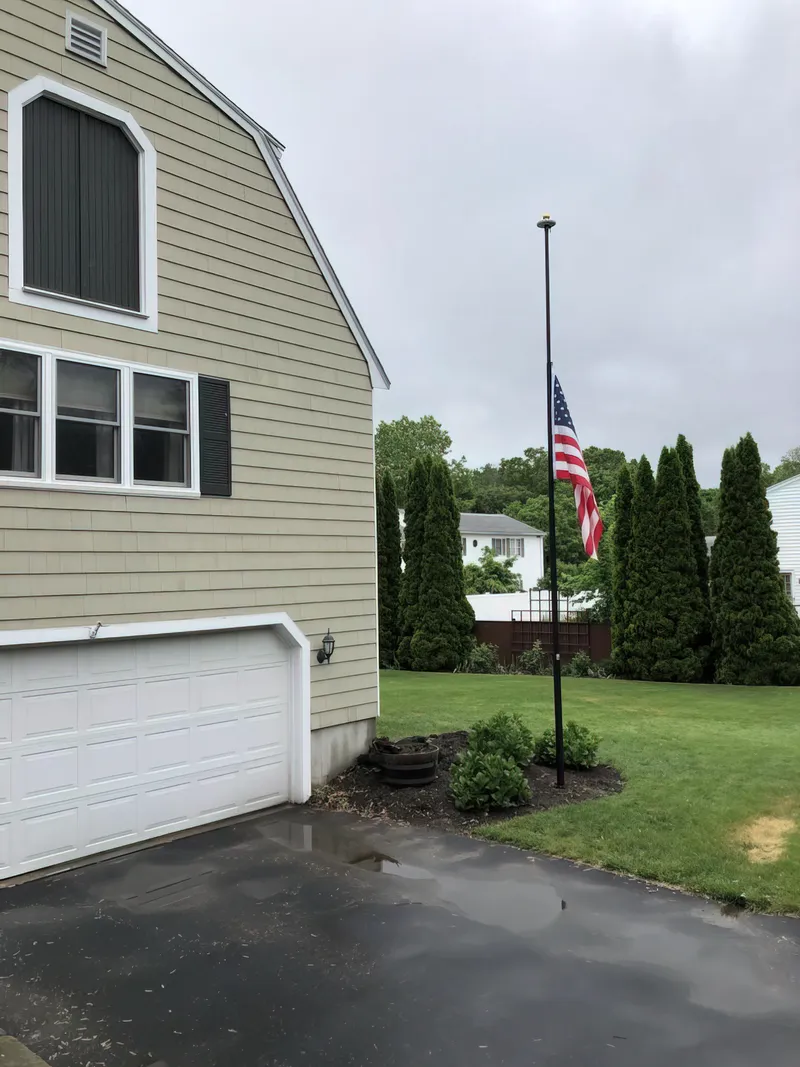 A Phoenix telescoping flagpole flying the American flag at a customer's home